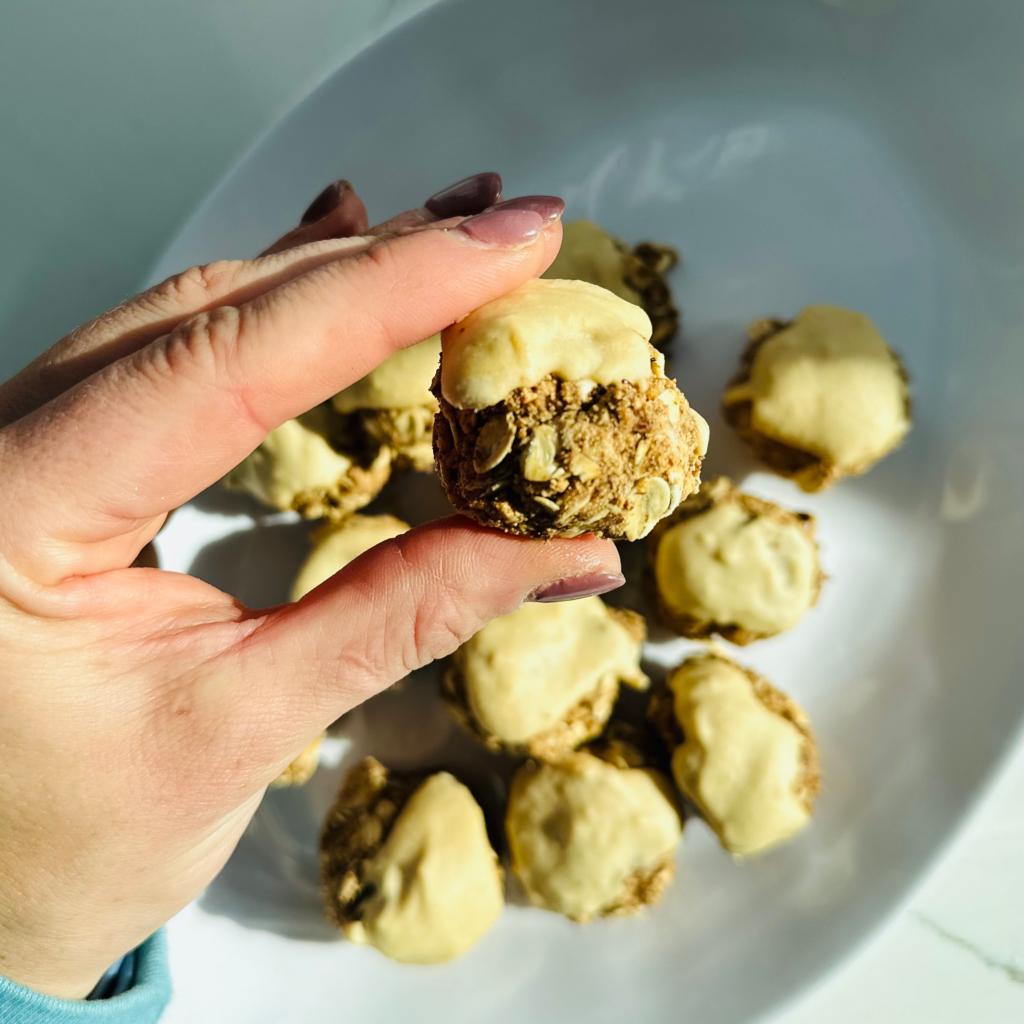 Bowl of small bite size protein balls with frosting.