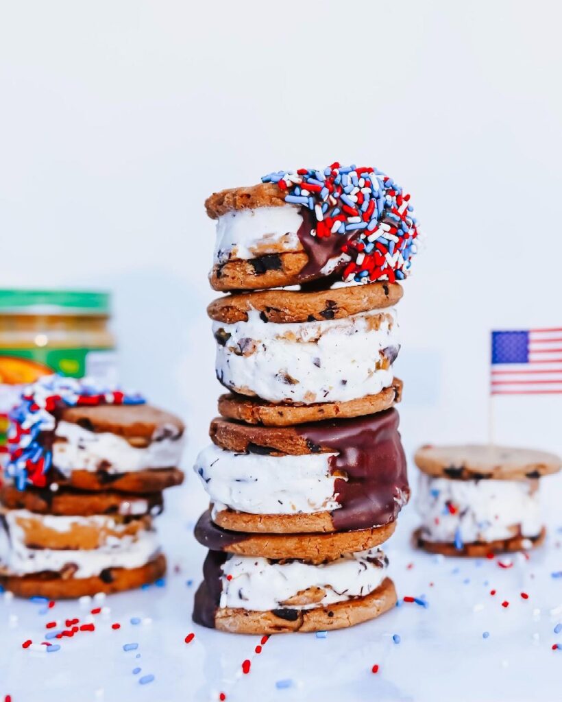 Four ice cream sandwiches dipped with red, white and blue sprinkles,