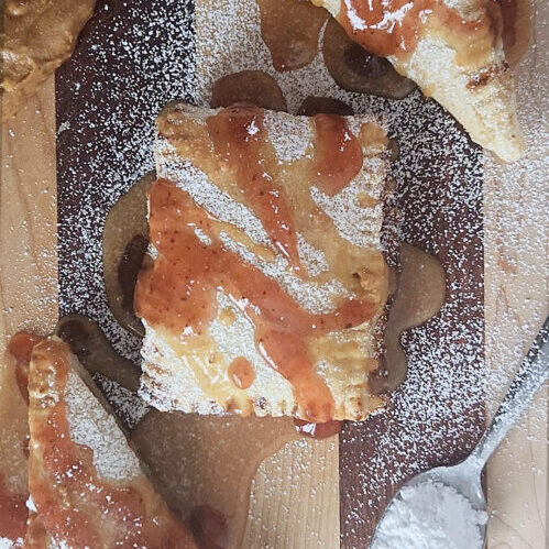 PB&J inside a puff pastry with jam and powdered sugar on top
