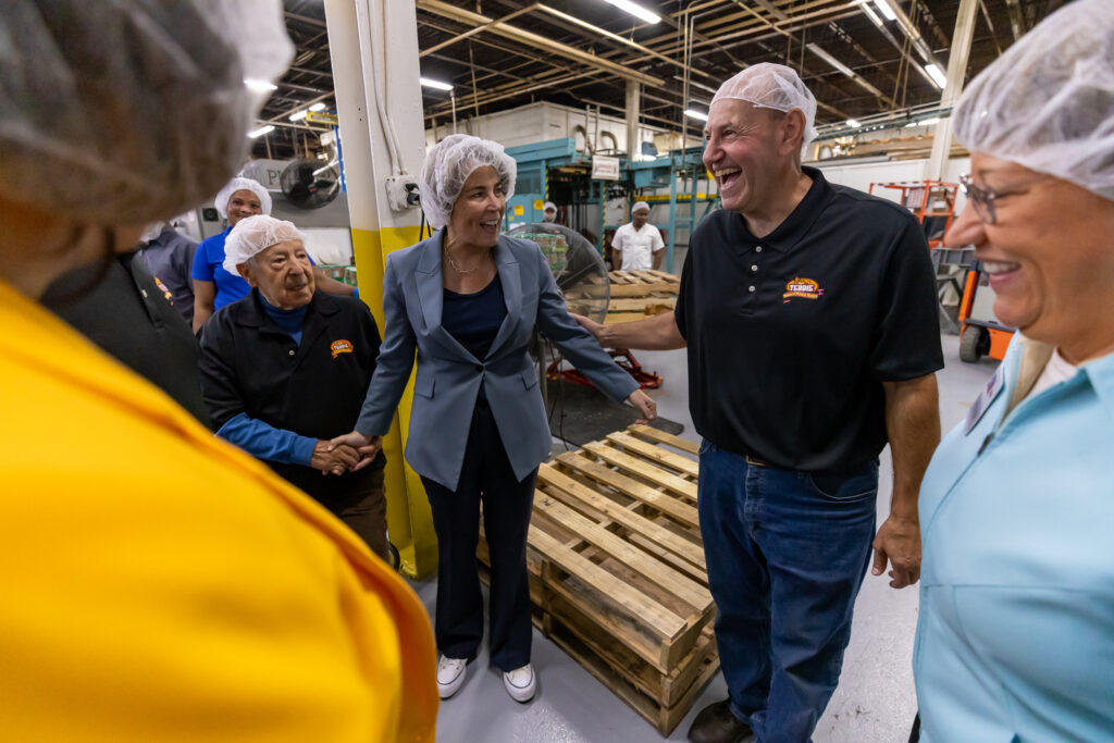 Governor Healey shaking hands with two Teddie Peanut Butter employees.